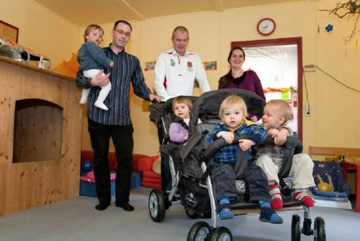 hinten v.l.: Tobias Lorenz und James Johnson von Round Table 93 mit Nadine Pawliki bei der Übergabe des Vierlingswagens in der Kinderkrippe  Flohzirkus Ulm.