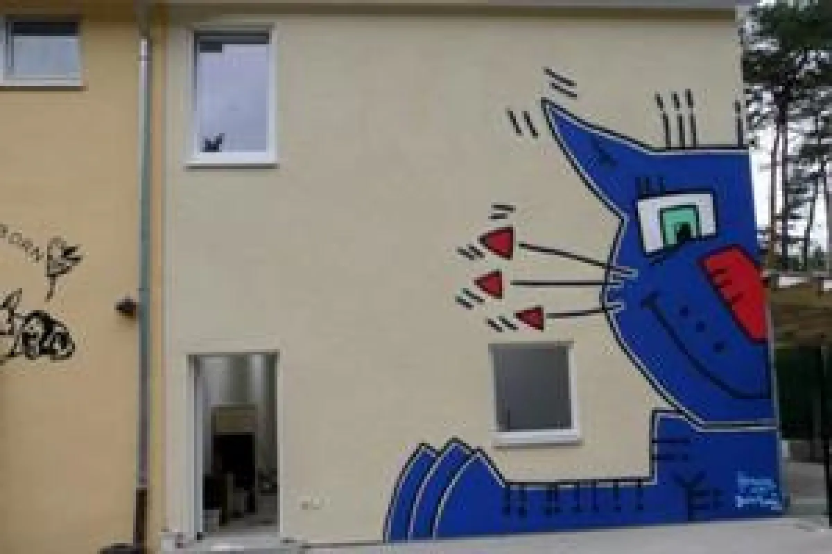Unverkennbar wirkt die gelbe Fassade mit dem blauen Katzenkopf wie ein Wahrzeichen auf die Besucher