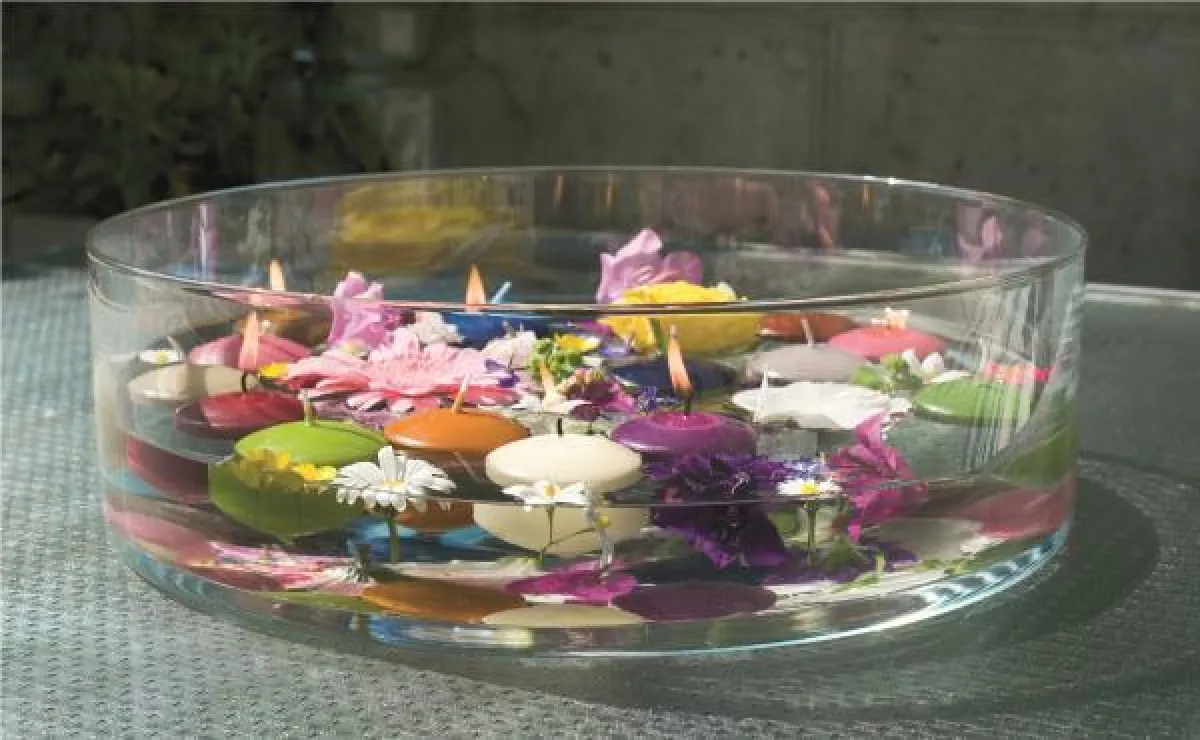 Wie ein schwimmender Minigarten präsentieren sich farbenfrohe Blüten mit bunten Schwimmkerzen! Foto: Gütegemeinschaft Kerzen