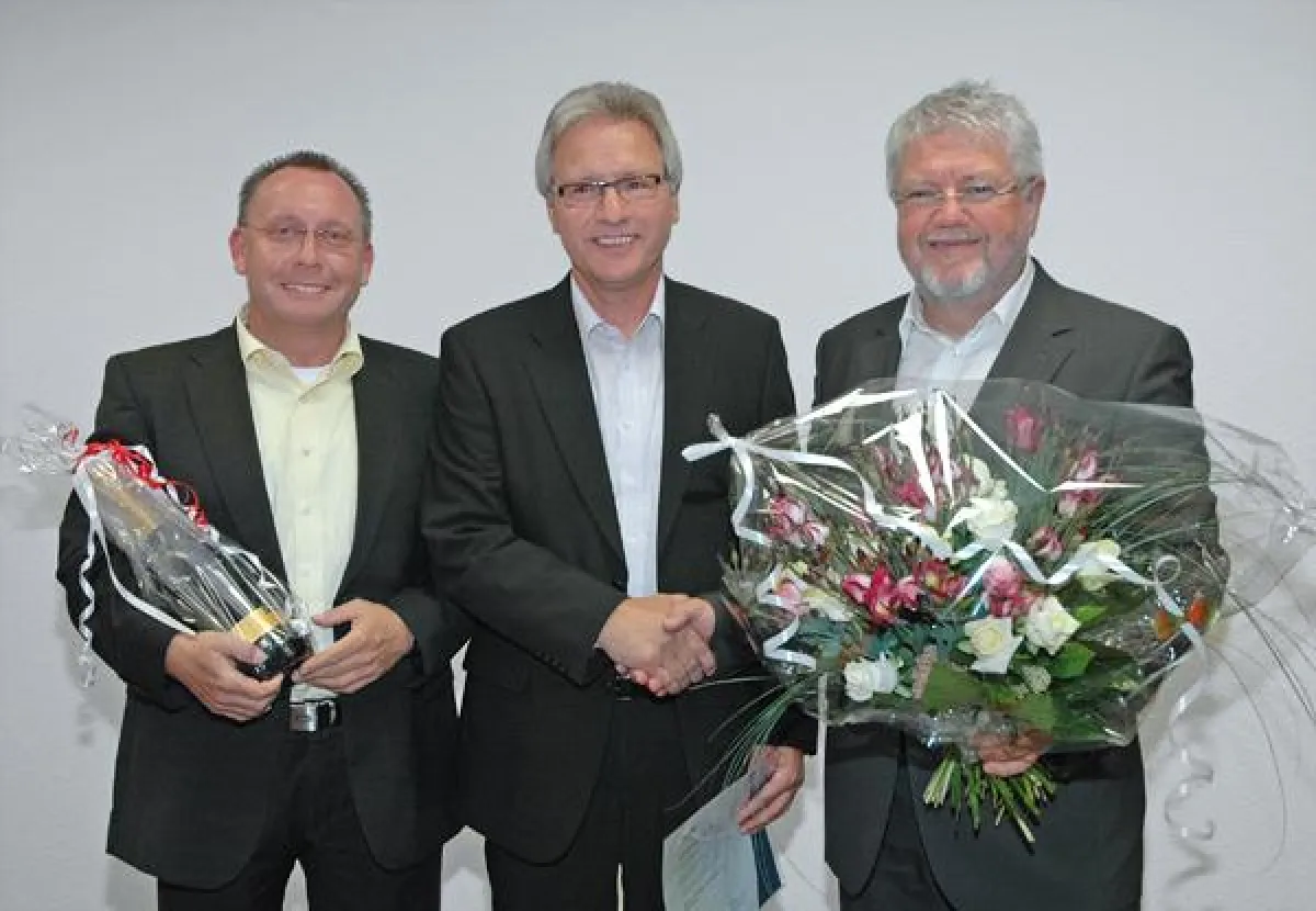 Die Namen der Personen von links nach rechts sind: Prokurist Jürgen Mühlfeit, Jubilar Gustav Kern, Prokurist Bernd Kunzmann.