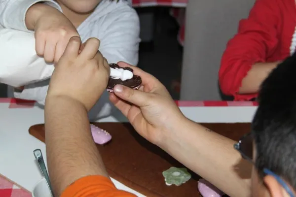 Bild: Strahlende Kinder beim Lebkuchenhausbau von HCC, Aktion Sonnenstrahl und Hannover Indians