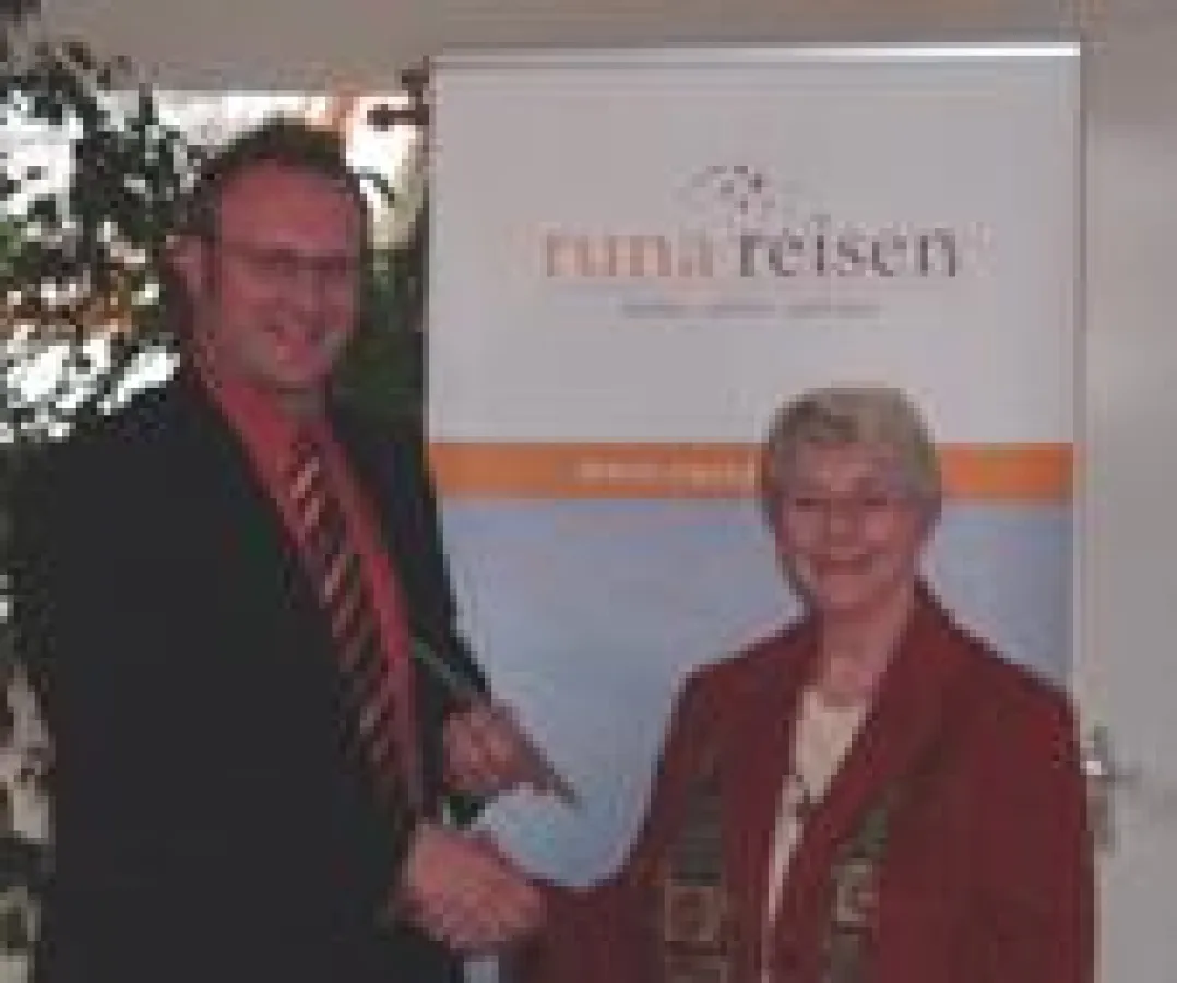 runa reisen Geschäftsführer Nils Wend bei der Überreichung des Reisegutscheins an die Gewinnerin Magdalene Frohn aus Gütersloh