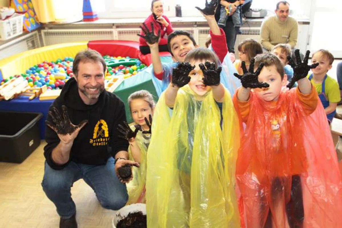 Die Kinder des Kindergartens „Fröbelchen“ haben sichtlich Spaß an der Herstellung der Nassbraunkohle