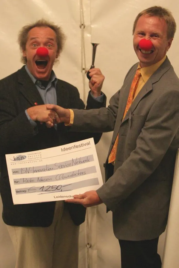 Stefan Posch von der ISN (rechts) übergibt den Spendenscheck an Hannes Urdl von den Clowndoctors