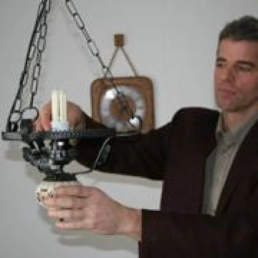 SWW-Energieberater Wolfgang Schugg tauscht eine alte Glühlampe gegen eine moderne Energiesparlampe aus. Foto: eza!