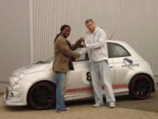 Bild: Mola Adebisi übergibt Fiat 500 an Magdeburger Gewinner des Zungen-Tattoo-Wettbewerbs der Games Convention