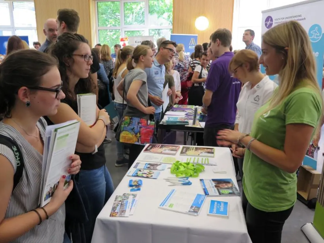 Interessierte Weltentdecker im Gespräch am Messestand