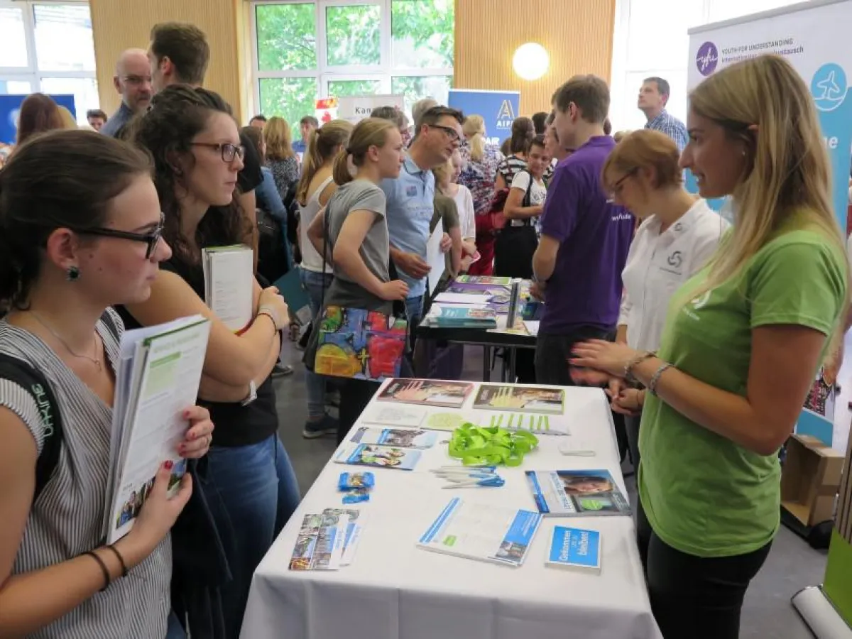 Interessierte Weltentdecker im Gespräch am Messestand