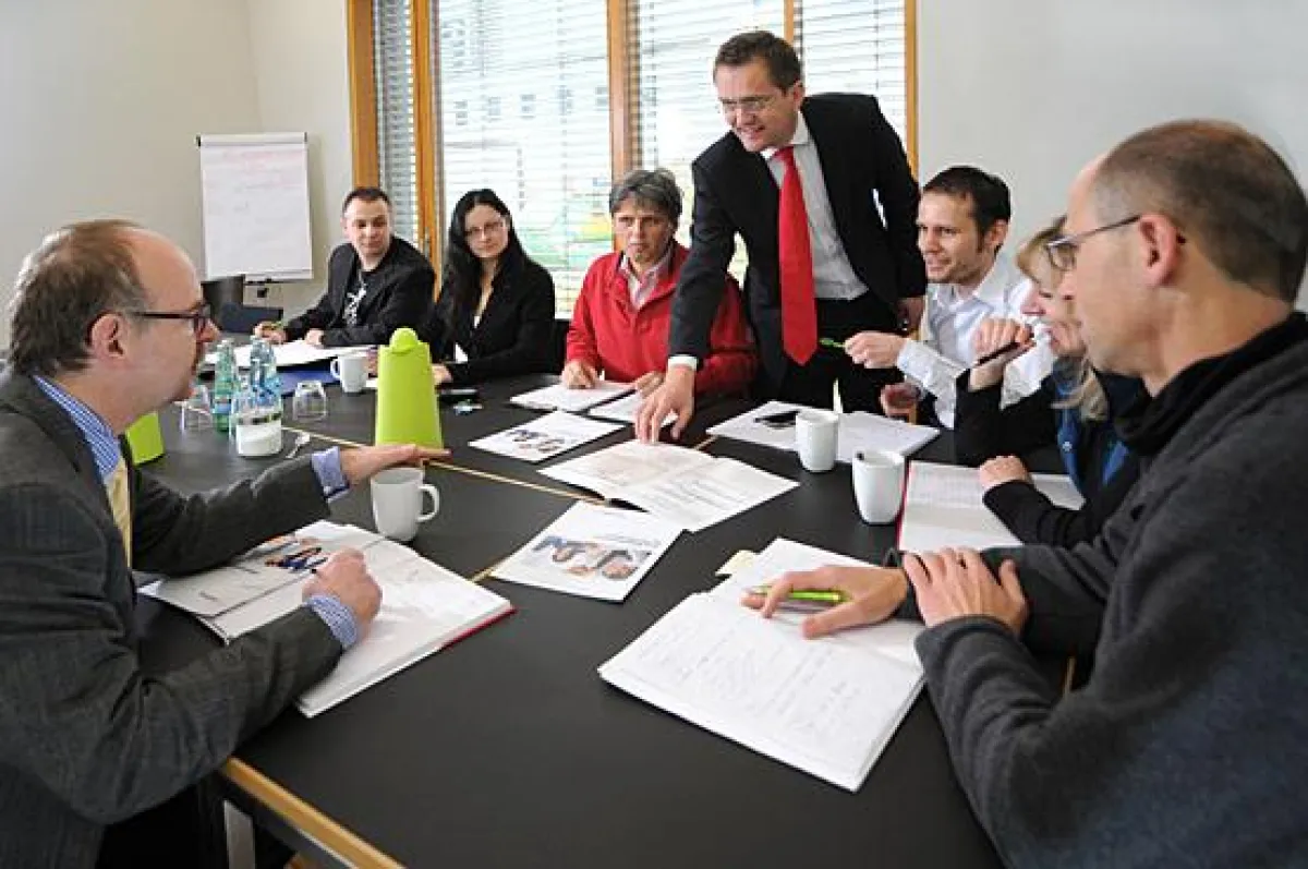 Steffen Kaden (mitte, stehend), Geschäftsbereichsleiter Vergabe mit dem Team des Geschäftsbereiche