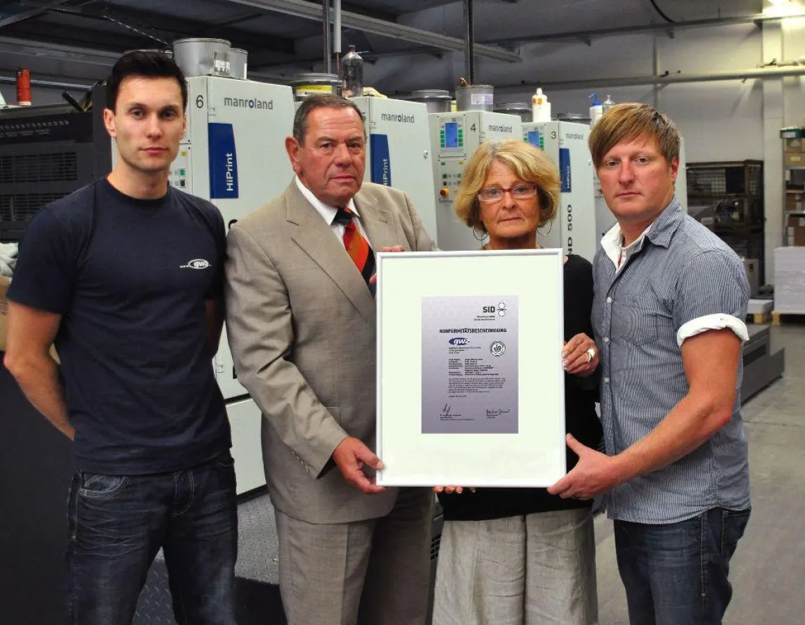 André und Christina Förster (Geschäftsleitung), Dr. Peter Hofmann (SID), Philipp Pfeiffer (Erster Drucker) mit der Urkunde (v.r.)