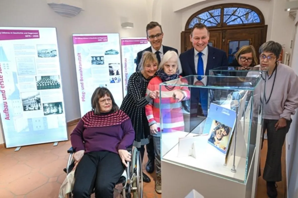 Dr. Markus Nachbaur und Dr. Berthold Broll, Vorstand Stiftung Liebenau, mit Besuchern der Ausstellun