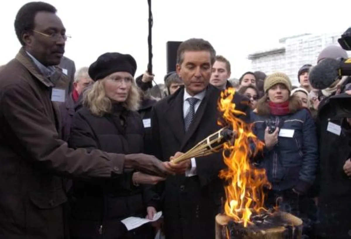 Ahmed Musa, Mia Farrow und Dr. Michel Friedman entzünden die symbolische olympische Fackel am Denkmal für die ermordeten Juden Europas in Berlin