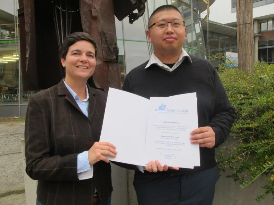 Kan-Wa Tang nimmt den Absolventenpreis des Fördervereins der Frankfurt UAS entgegen.