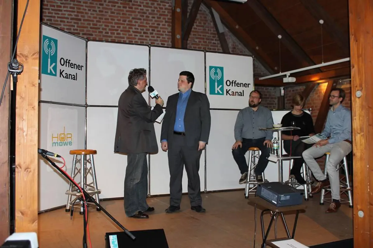 Christoph Rothe (r.) mit Hörmöwe-Moderator Jörg Lotze (l.) auf der Bühne. Ganz rechts: die Jury