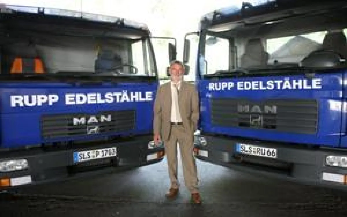 Gerhard Schramm, Geschäftsführer der Firma Rupp Edelstähle, vor zwei LKW des eigenen Fuhrparks.