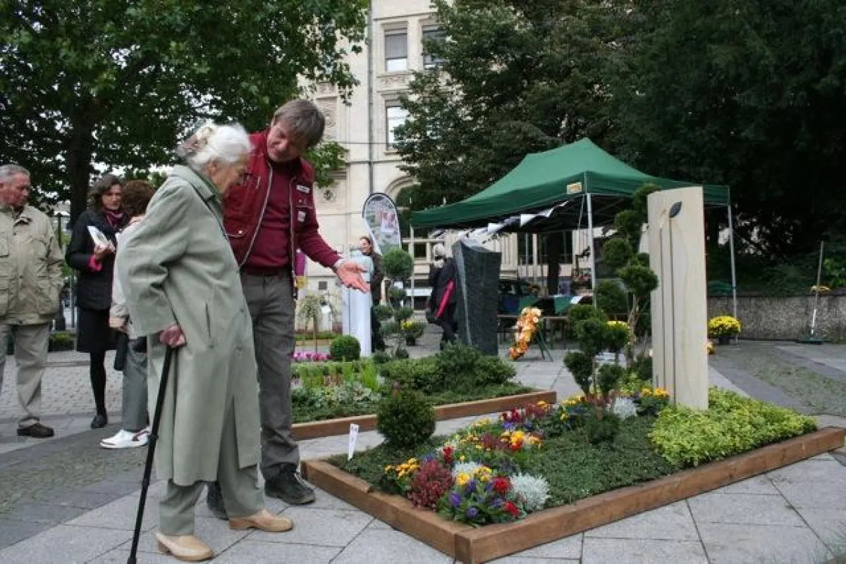 Ein Friedhofsgärtner berät auf dem Tag des Friedhofs 2010 eine Besucherin über kreative Grabgestaltung. (Bildnachweis: BdF)