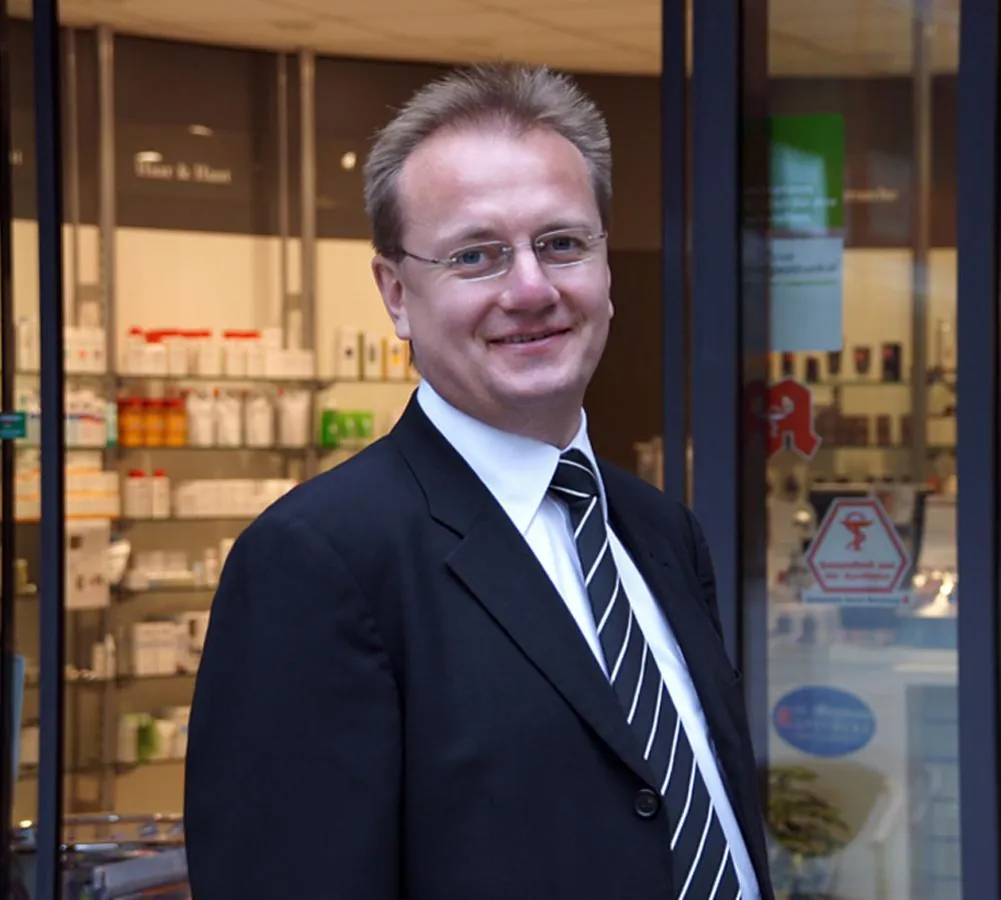 Mammut Pharma-Gründer Reiner Christensen vor einer Mutter-Kleinkind-Apotheke