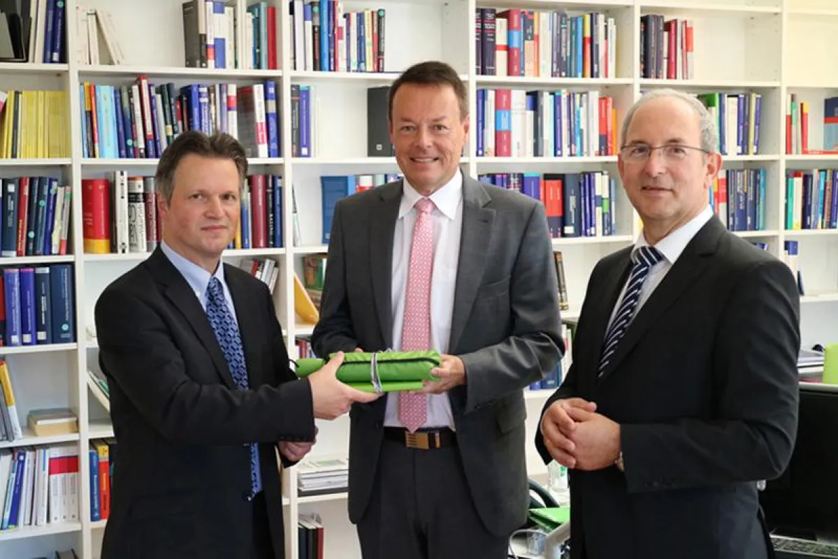 Verwaltungsleiter Thomas Herz (links) und Rektor Prof. Dr. Ottmar Schneck (rechts) begrüßen Klaus Ta