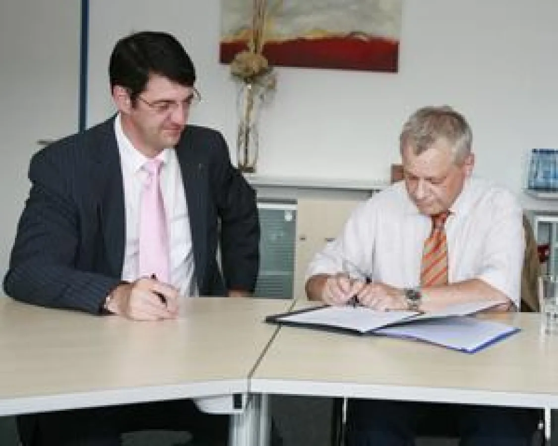 Rainer Starke, Schulleiter des Viktoria-Luise-Gymnasiums, unterzeichnet den Vertrag. Links: HSW-Präsident Prof. Dr. Volkmar Langer