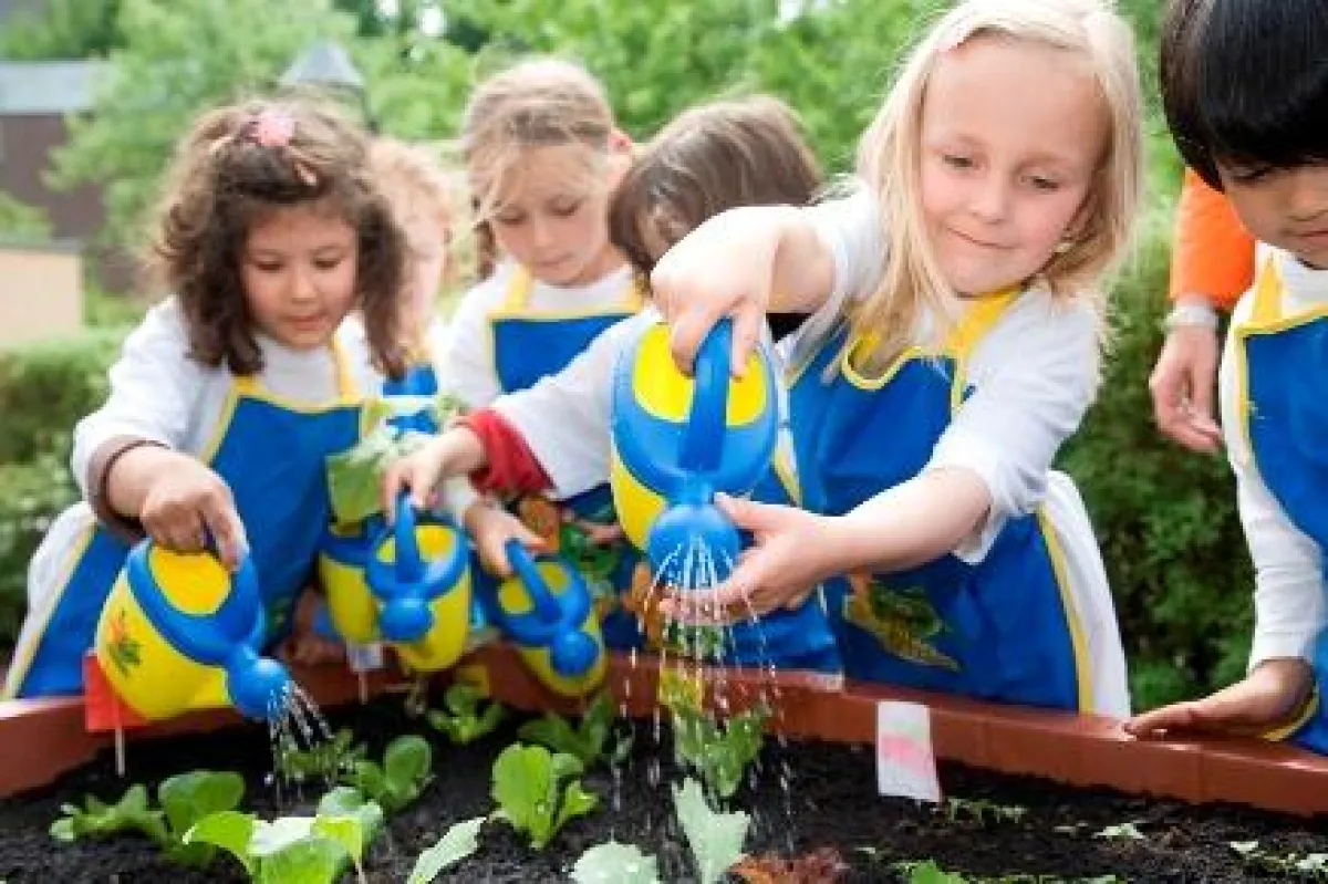 Kinder bepflanzen und bewässern ein Hochbeet