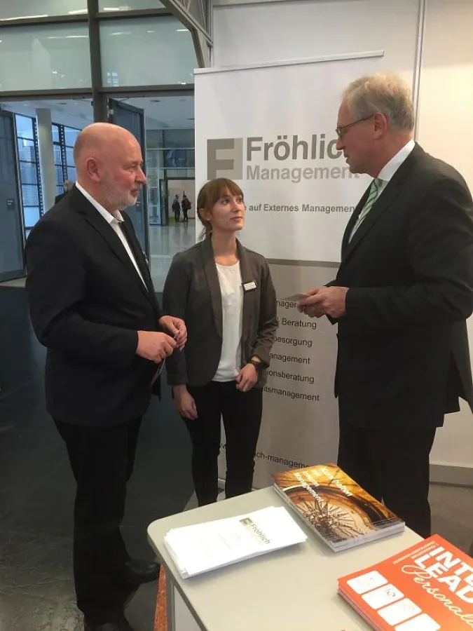 Im Gespräch: Edmund Fröhlich (li.) und Manuela Dabitsch von Fröhlich Management informierten Richard Bartsch, Bezirkstagspräsident von Mittelfranken, an ihrem Stand. Foto: FM