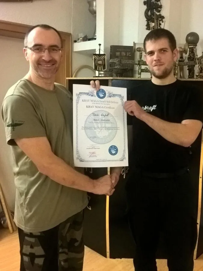 Chief Instructor Jürgen Köhler (li.) überreicht Dirk Oefele die Urkunde zur bestandenen Prüfung.