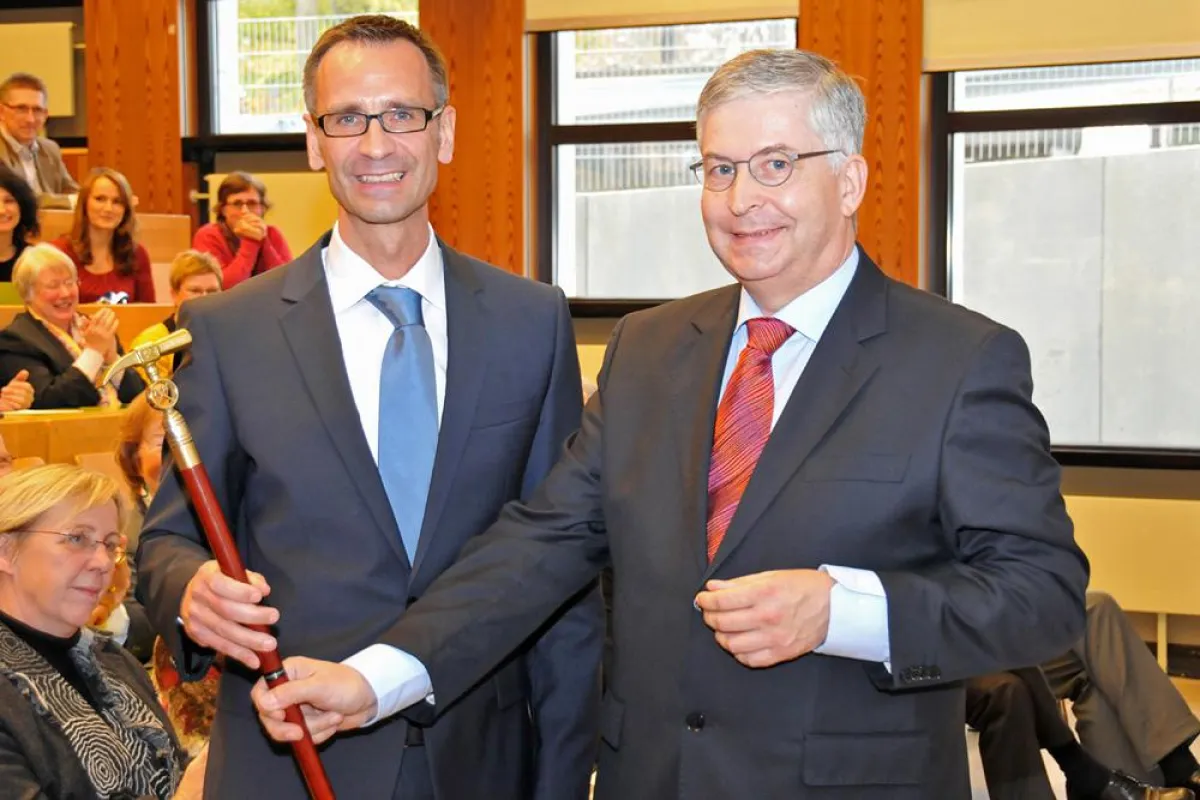Prof. Dr. R. Viebahn überreicht Prof. Dr. M. Adamzik einen Steigerstock als Willkommensgeschenk.