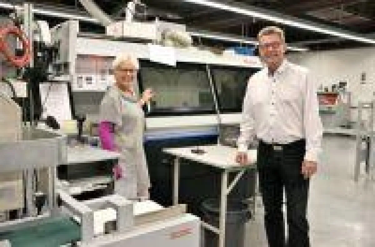 Birgit Dornbusch von Fujifilm freut sich mit Gebietsleiter Fred Zühlke über die Zuverlässigkeit des Klebebinders BQ-480.