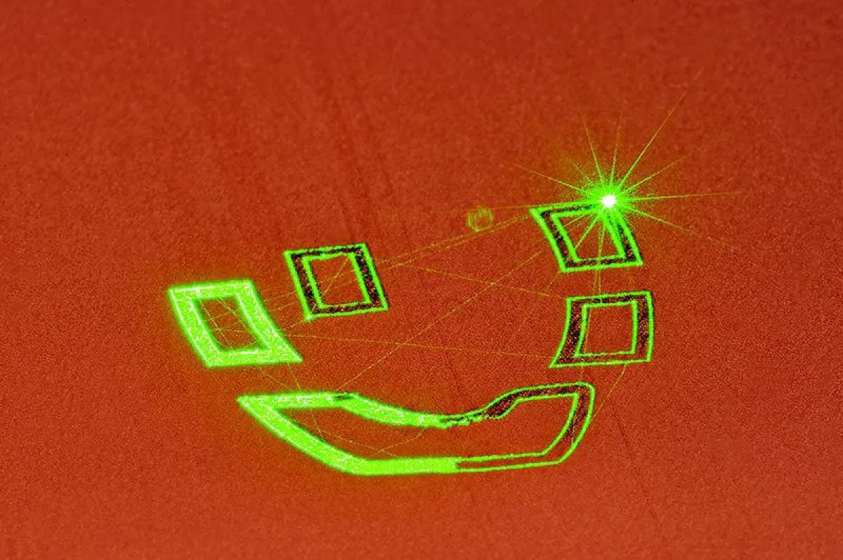 Bild 1: Belichtung einer Einzelschicht im SLM-Prozess mit grünem Laserstrahl zur Herstellung einer innengekühlten Spule für die induktive Wärmebehandlung. (© Fraunhofer ILT, Aachen. )