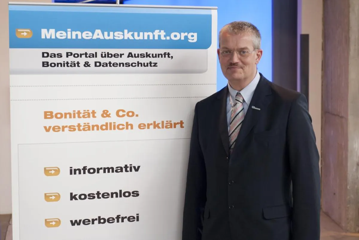 Siebo Woydt, Geschäftsführer der CEG, neben dem Banner der Initiative MeineAuskunft.org