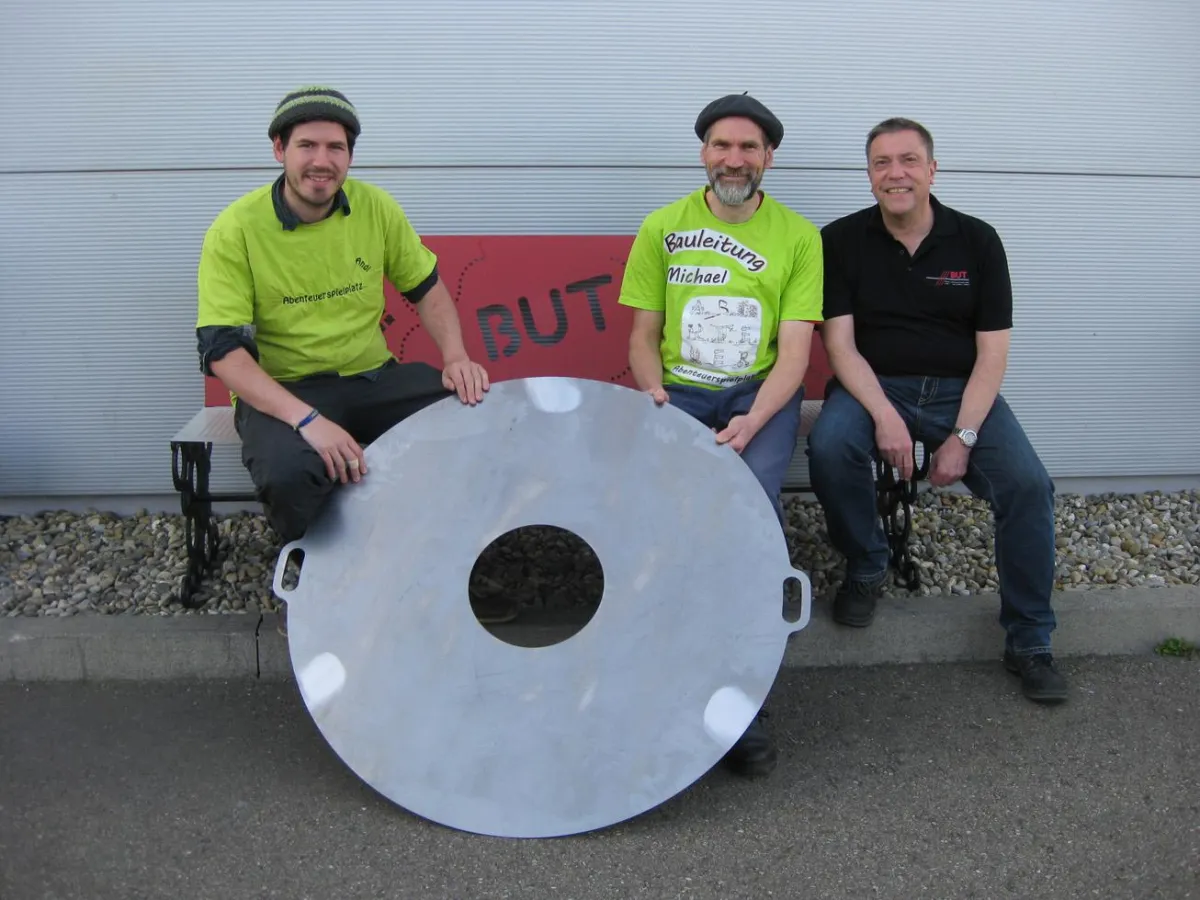 Geschäftsführer Achim Redt (r.) übergab die Grillplatte an das Spielplatzteam