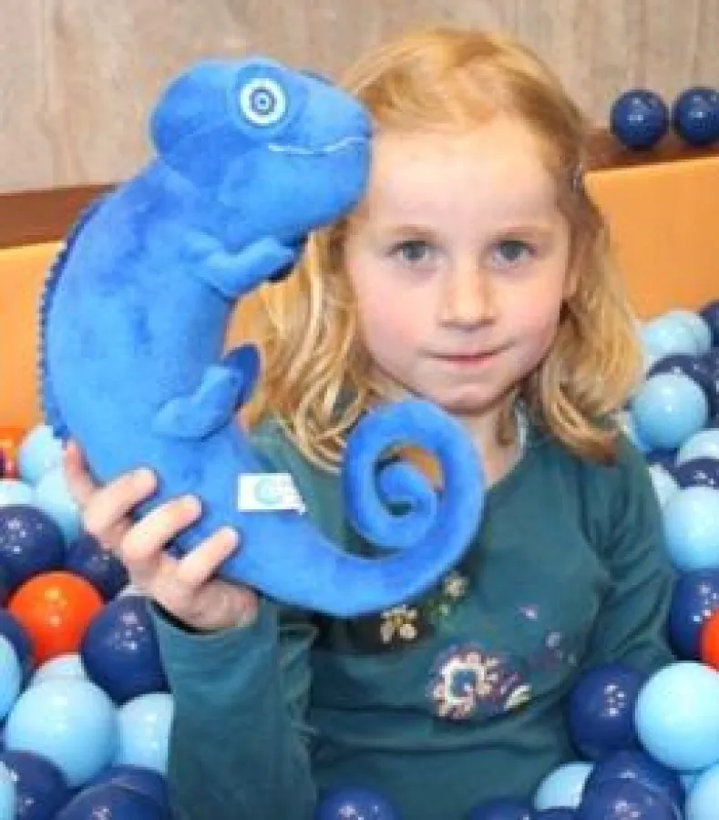 Emily (6) zeigt das Chamäleon-Maskottchen, das nun einen Namen bekommt (Foto: Kinderhörzentrum)