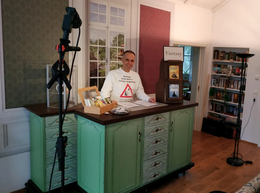 Autor Frank Friedrichs am improvisierten Messestand im Wohnzimmer
