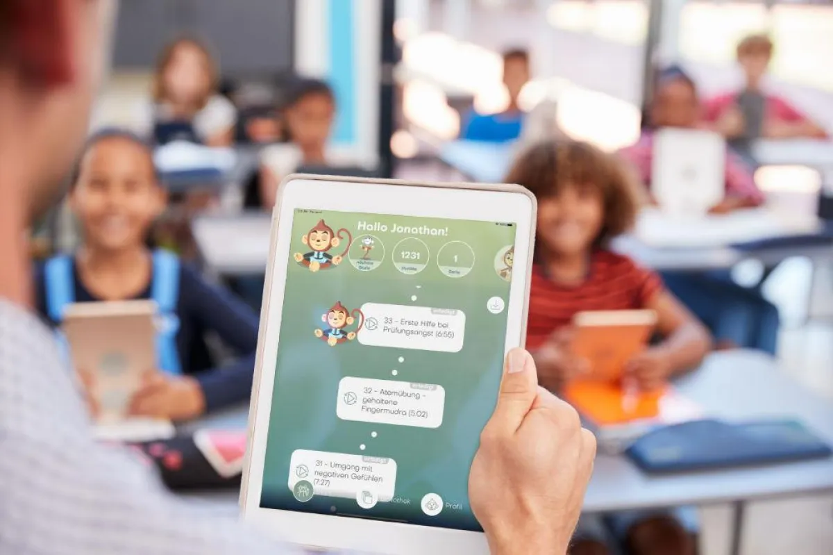 Lehrer mit der BuddhaBoo-App vor einer Klasse