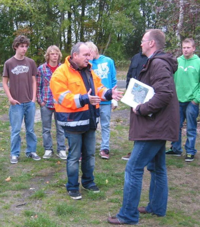 Erwin Rechsteiner (orange Jacke) mit Hambührens Bauamtsleiter Niels Jürgensen und den jugendlichen Skatern