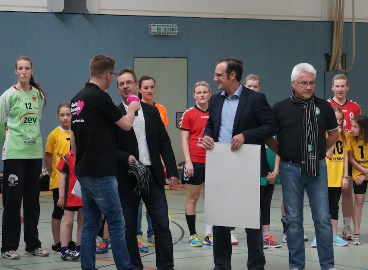 Christof Eul von der absatzplus GmbH (Mitte) beim Überreichen der Schals.