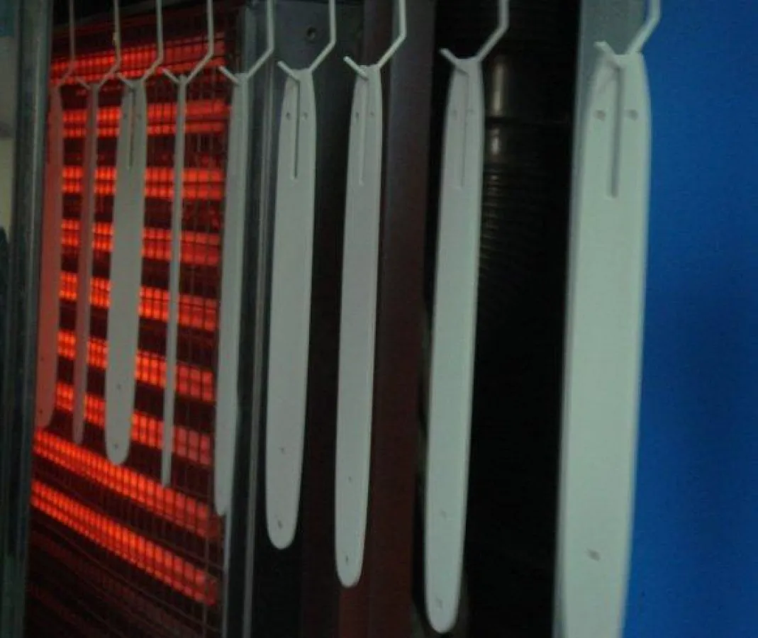 Pulverlack auf flachen Metallteilen für Kettensägen wird schneller gehärtet und verbraucht weniger Produktionsfläche als mit einem gasbefeuerten Trocknungsofen.