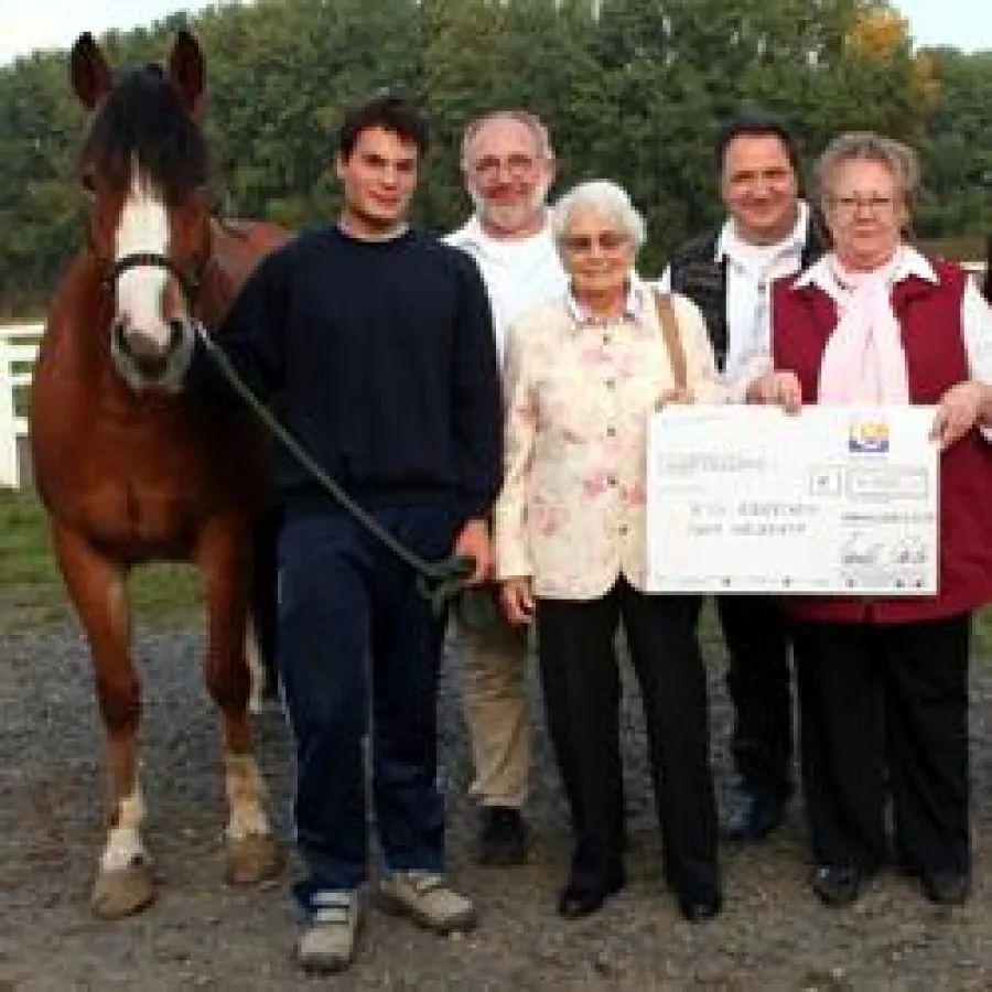 Scheckübergabe mit Reitschulpferd Fallone, FSJler Daniel Zimmer (links) und Frau Ursula Carls (3.v.l.)