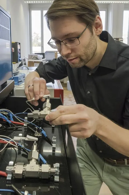 Forschung am Wasser-Elektrolyt: Empa-Forscher Ruben-Simon Kühnel schliesst eine Test-Zelle mit der konzentrierten Salzlösung ans experimentelle Ladegerät an. (Empa)
