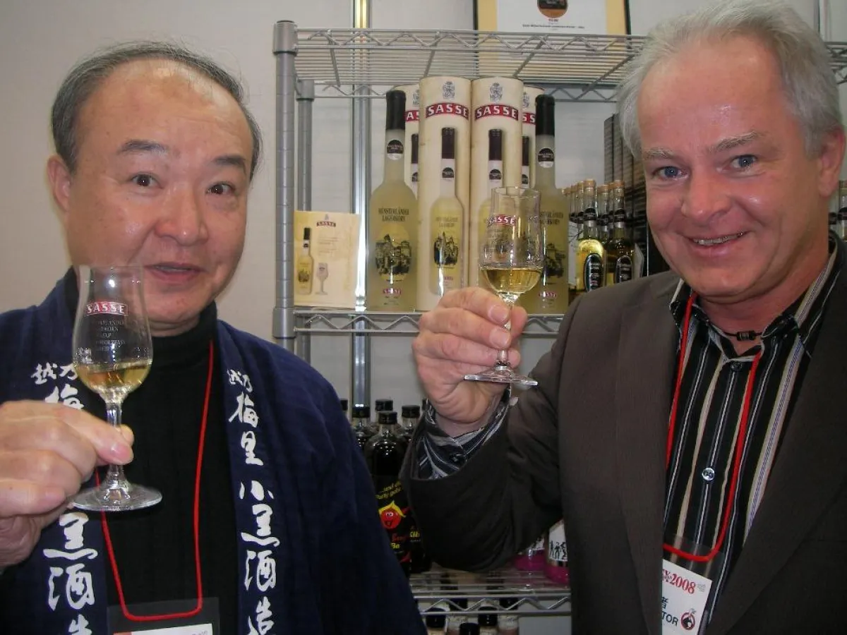 Sumie Ichinose, Vorstand des Sasse Importeurs Avante (links) und Friedhelm Egbert, Exportmanager Sasse Feinbrennerei (rechts) stoßen auf eine erfolgreiche Messe an.