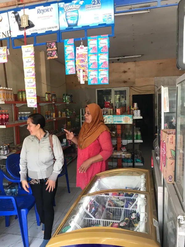 Begeistert zeigt Farida die Regale ihres Ladens, die sie jetzt mit neuen Produkten füllen kann