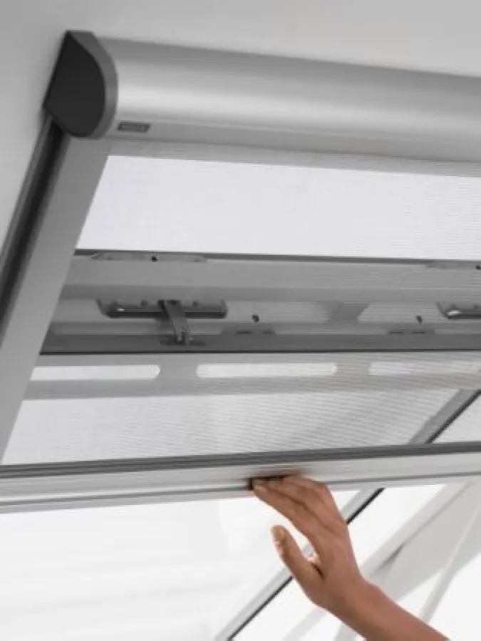 Anders als viele herkömmliche Insektenschutz-Lösungen ist das VELUX Modell schienengeführt. Der Aluminum-Farbton der Führungsschienen und des Rollokasten unterstreicht das moderne Design. Foto: VELUX 