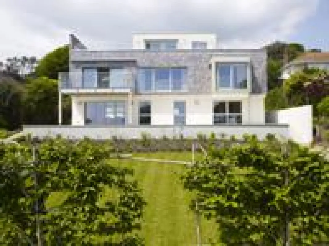 Designhaus Griffen mit einer Kombination aus traditionellen Holzschindeln und schlichter Putzfassade