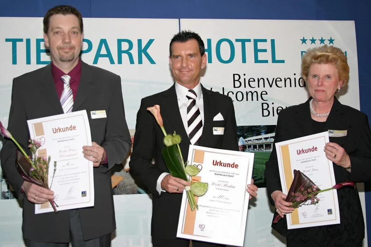 Matthias Hirsch vom Hotel Merkur (Mitte) nimmt mit anderen Preisträgern seine Urkunde für die Prämierung als eines der „Beliebtesten Hotels Deutschlands“ entgegen.