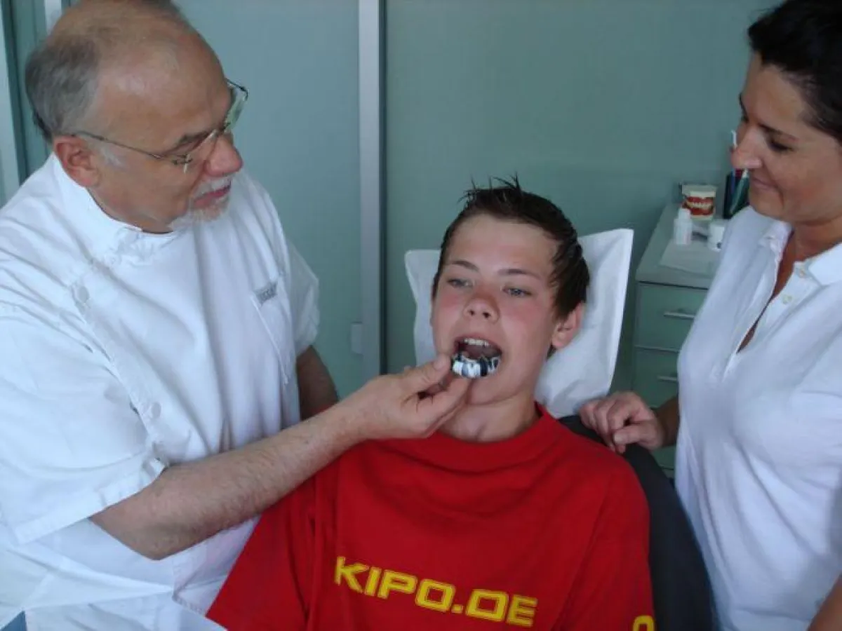 Dr. Albert Pietsch überprüft den Mundschutz von Jan-Eric Ritter