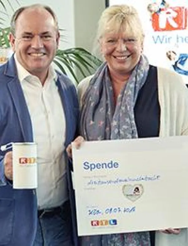 RTL Moderator Wolfram Kons überreichte Ester Peter den Spendenscheck.