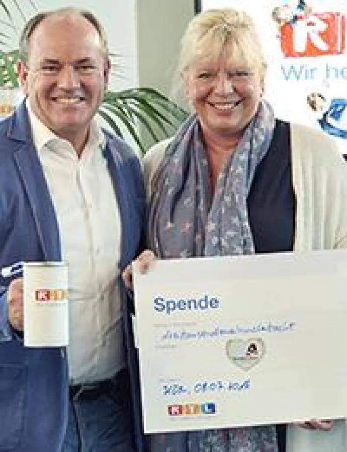 RTL Moderator Wolfram Kons überreichte Ester Peter den Spendenscheck.