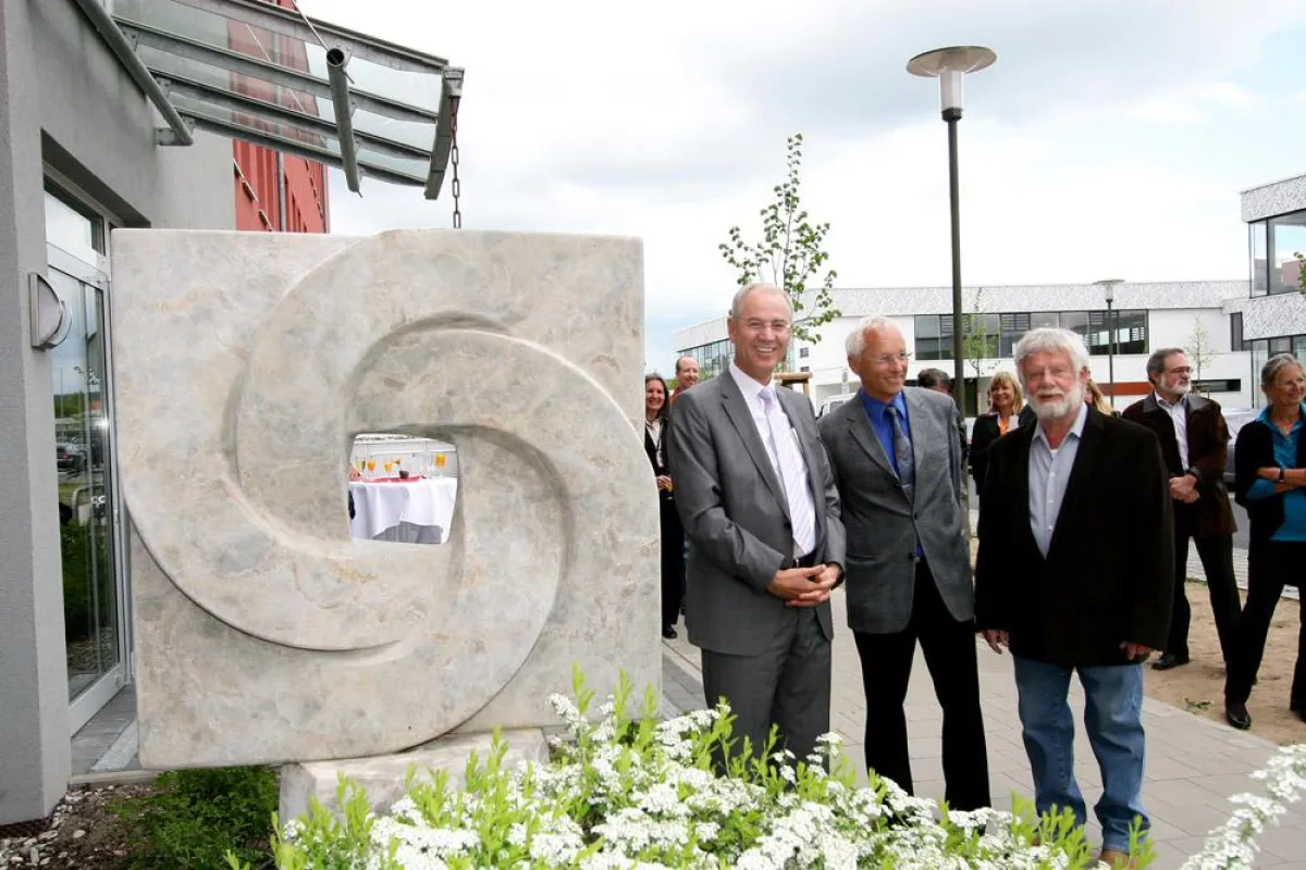 Oberbürgermeister Dr. Siegfried Balleis, MAUSS-Inhaber Reinhard Daeschler und Künstler Bernhard Rein (v.l.n.r.) vor der Steinskulptur aus oberfränkischem Kalksandstein. Foto: Mile Cindric