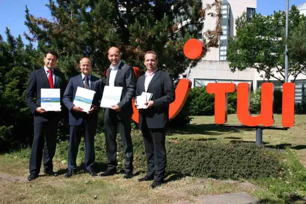 Von rechts: Steffen Böhnke (TUI Product Director Amerika) u. Dr. Ingo Burmester (TUI Executive Dir. Mittel- & Langstrecke) überreichen das Handbuch Jürgen Stütz (Sol Meliá VP Sales) u. Juan José Calvo