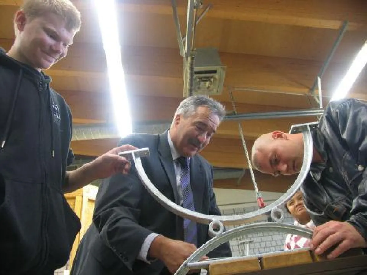 Eine Sitzbank für den guten Zweck: Josef Rief (mitte) in der Ausbildungswerkstatt des BBW